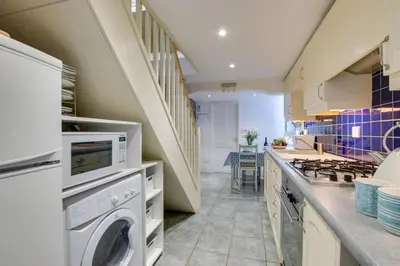 a kitchen with a washer and dryer and a staircase at 2 Bed in St Ives oc-tee009 in St Ives
