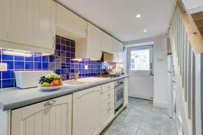 a kitchen with white cabinets and blue tiles at 2 Bed in St Ives oc-tee009 in St Ives