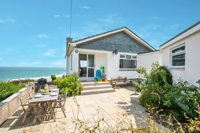 a house with a patio and the ocean in the background at 3 Bed in St. Ives oc-trecar in St Ives