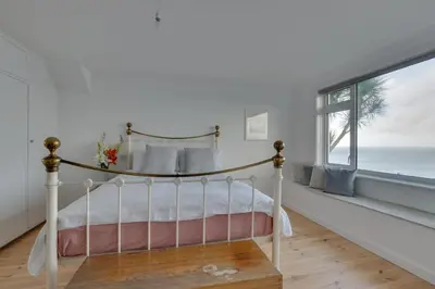 a bedroom with a bed with a view of the ocean at 3 Bed in St. Ives oc-trecar in St Ives