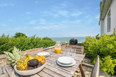 a wooden table with a bowl of fruit and a glass of orange juice at 3 Bed in St. Ives oc-trecar in St Ives