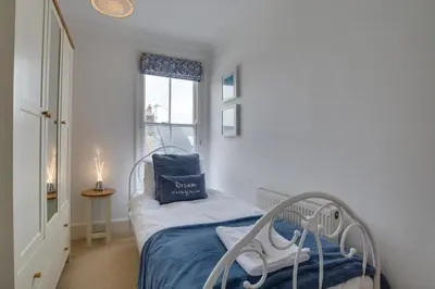 a bedroom with a bed with a blue blanket and a window at 3 Bed in St Ives oc-twp21 in St Ives