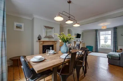 a dining room table with chairs and a vase of flowers at 3 Bed in St Ives oc-twp21 in St Ives