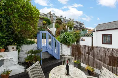 a bottle of wine sitting on a table on a patio at 3 Bed in St Ives oc-twp21 in St Ives