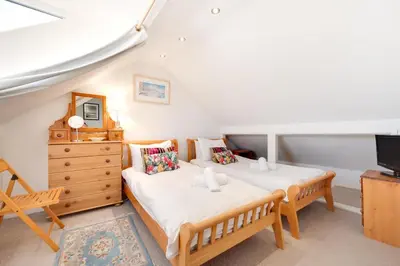 a bedroom with two beds and a dresser and a tv at 3 Bed in St Ives oc-twp32 in St Ives