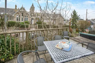 a table with a cup of coffee on a balcony at 3 Bed in St Ives oc-twtc11 in St Ives