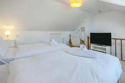 two beds in a hotel room with a tv at 3 Bed in St Ives oc-twtc11 in St Ives