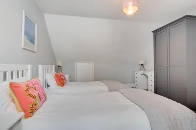 a bedroom with two beds with white sheets and pink pillows at 4 Bed in St. Ives oc-uppcr in St Ives