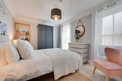 a bedroom with a white bed and a pink chair at 2 Bed in St. Ives oc-upper4 in St Ives
