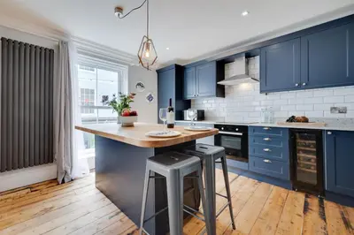 a kitchen with blue cabinets and a island with stools at 2 Bed in St. Ives oc-upper4 in St Ives