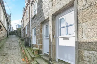 an alley with a white door on a brick building at 3 Bed in St Ives oc-vgn28 in St Ives