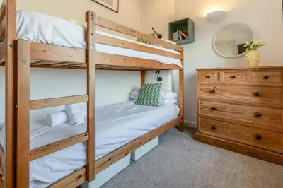 a bedroom with two bunk beds and a dresser at 3 Bed in St Ives oc-vgn28 in St Ives