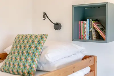 a bedroom with a bed and a shelf with books at 3 Bed in St Ives oc-vgn28 in St Ives