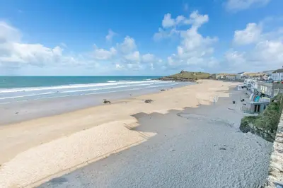 an empty beach with people walking on the sand at 3 Bed in St Ives oc-vgn28 in St Ives