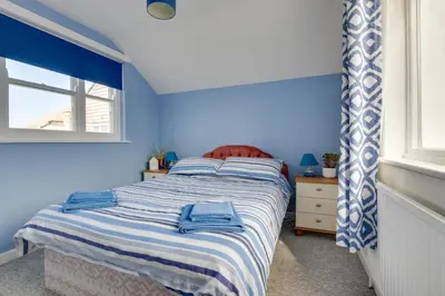 a bedroom with a bed with blue walls and a window at 3 Bed in St. Ives oc-virg14 in St Ives