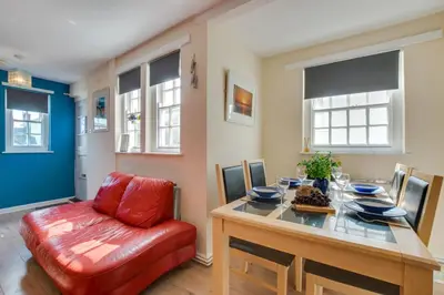 a dining room with a table and a red chair at 3 Bed in St. Ives oc-virg14 in St Ives