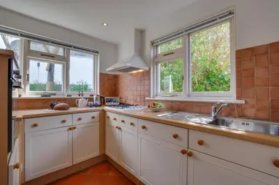 a kitchen with white cabinets and a sink and two windows at 2 Bed in St. Ives oc-wesh4 in St Ives