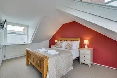 a bedroom with a bed and a red wall at 2 Bed in St Ives oc-wyp026 in St Ives