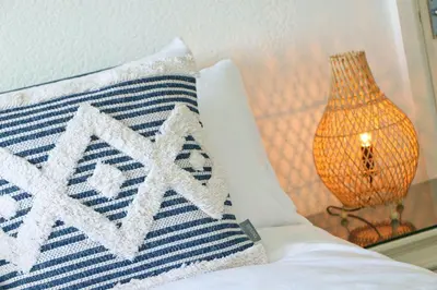 a pillow on a bed next to a lamp at Coastal retreat surrounded by open countryside in Saint Ervan