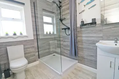 a bathroom with a shower and a toilet and a sink at Coastal retreat surrounded by open countryside in Saint Ervan