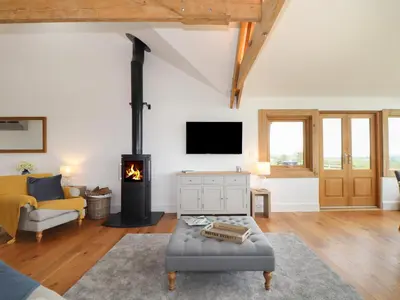 a living room with a fireplace and a couch at Trevilges Cottage in Helston