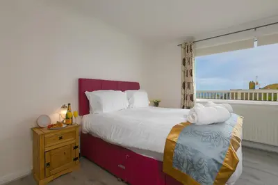 a bedroom with a large bed and a window at Ocean Air in Carbis Bay
