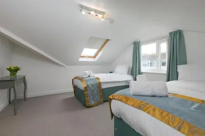 a bedroom with two beds and a window at Ocean Air in Carbis Bay