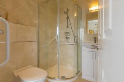 a bathroom with a shower with a toilet and a sink at Ocean Air in Carbis Bay