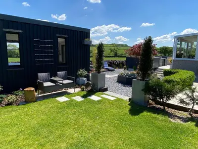 a backyard with a black house and green grass at Ashlea in Launceston
