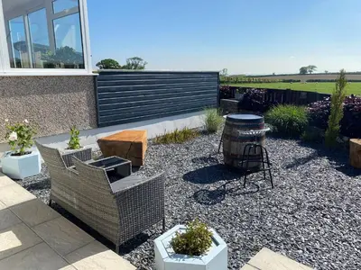 a garden with chairs and a barrel and a table at Ashlea in Launceston