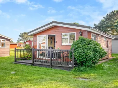 a pink house with a fence in a yard at Skylarks in St Merryn