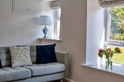a living room with a couch and two windows at Finest Retreats - Trethew Cottage in Carnbrea