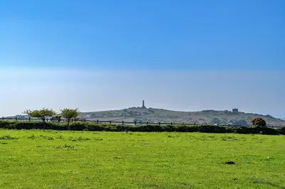 a field of green grass with a hill in the background at Finest Retreats - Trethew Cottage in Carnbrea