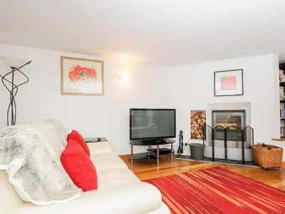 a living room with a white couch and a tv at Great Brightor Cob Barn in Bodmin