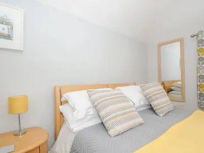 a bedroom with a bed with two pillows and a mirror at Great Brightor Cob Barn in Bodmin