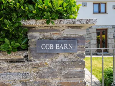 a sign for a cob bank on a stone wall at Great Brightor Cob Barn in Bodmin