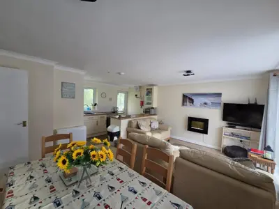 a living room with a table with flowers on it at 17 River Banks in Liskeard