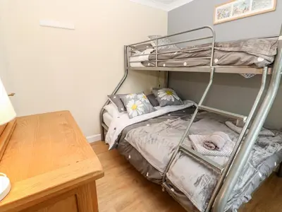 a bedroom with a bunk bed and a wooden table at 17 River Banks in Liskeard