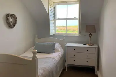a bedroom with a bed and a window and a dresser at Folly Farm Cottage, Cosy, Secluded near to St Ives in St Ives