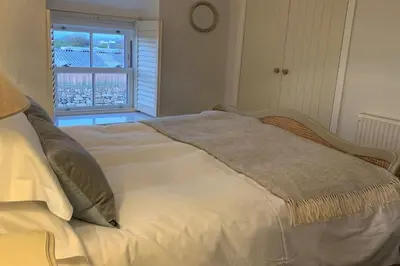 a white bed with a blanket on it in a bedroom at Folly Farm Cottage, Cosy, Secluded near to St Ives in St Ives