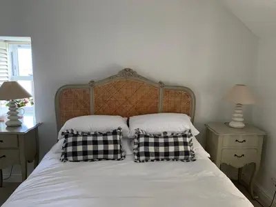 a bed with two black and white pillows on it at Folly Farm Cottage, Cosy, Secluded near to St Ives in St Ives