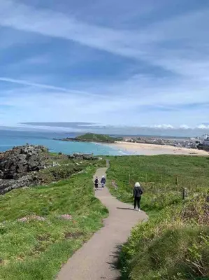 a group of people walking down a path near a beach at Folly Farm Cottage, Cosy, Secluded near to St Ives in St Ives