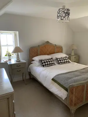 a bedroom with a bed with two night stands and a window at Folly Farm Cottage, Cosy, Secluded near to St Ives in St Ives