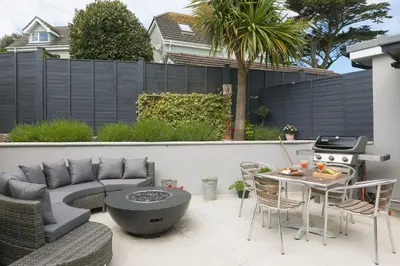 a patio with a couch and a table and a grill at Willows in St Ives
