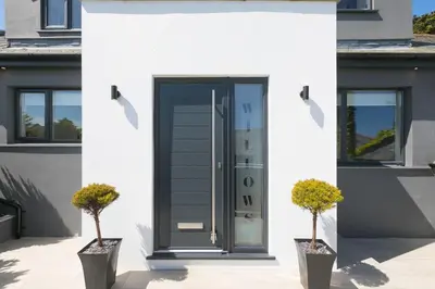 a front door of a house with two potted plants at Willows in St Ives