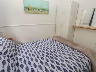 a bedroom with a bed with a blue and white comforter at Badger Sett in Granite Henge near Looe in Looe