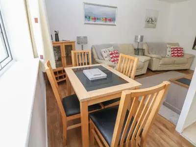 a living room with a wooden table and chairs at Badger Sett in Granite Henge near Looe in Looe