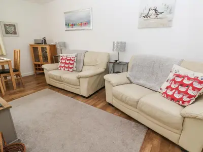 a living room with two couches and a rug at Badger Sett in Granite Henge near Looe in Looe