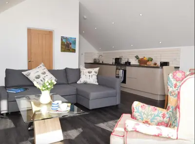 a living room with a couch and a table at Fernsplatt Farm Lodge in Truro