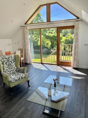 a living room with a couch and a glass table at Fernsplatt Farm Lodge in Truro